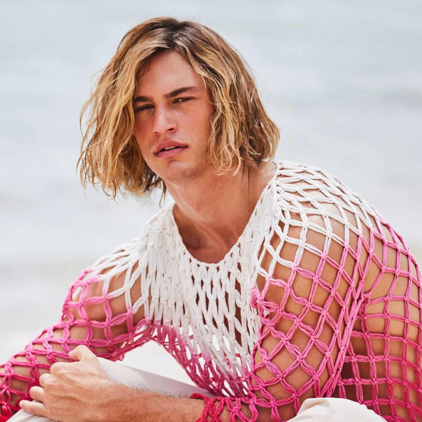 Model showcasing healthy colour-treated hairstyle by the sea.